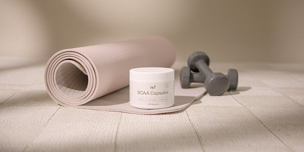 nu3 BCAA in capsule su tappetino fitness con manubri