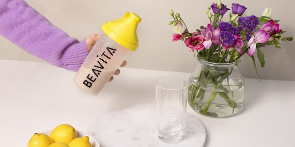 BEAVITA Slim Shaker con bicchiere e fiori sul tavolo