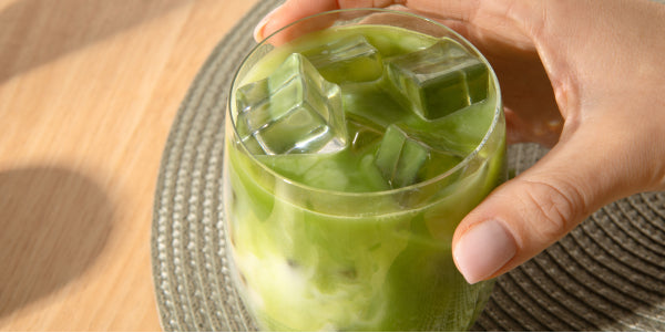 Latte freddo al matcha in un bicchiere con cubetti di ghiaccio