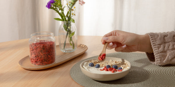Una donna cosparge le bacche di goji sul suo muesli