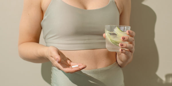 Donna con una capsula e un bicchiere in mano