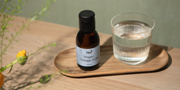 Olio omega-3 con un bicchiere d'acqua