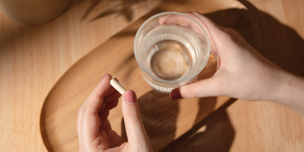 Una capsula con un bicchiere d'acqua