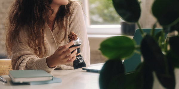 Donna fa uno spuntino con la barretta proteica alla scrivania