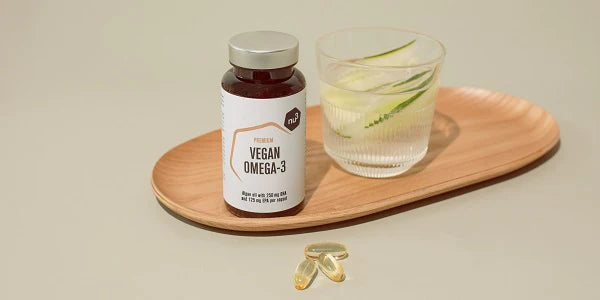 Omega-3 vegan con un bicchiere di acqua