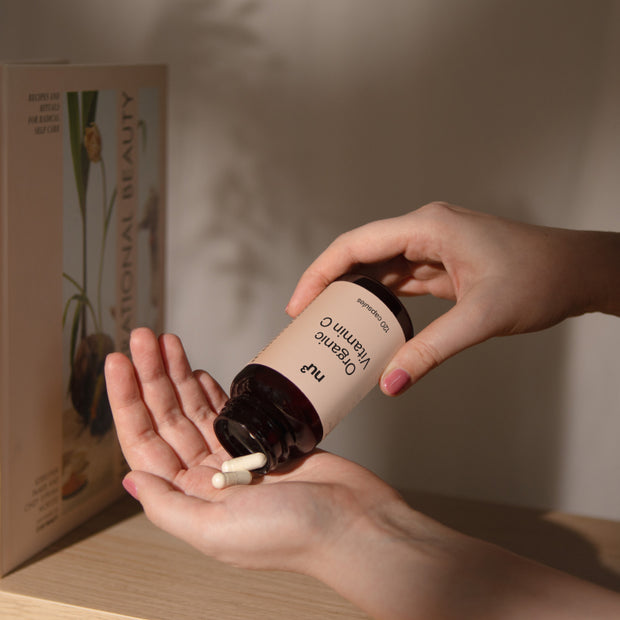 Mano con capsule di vitamina C