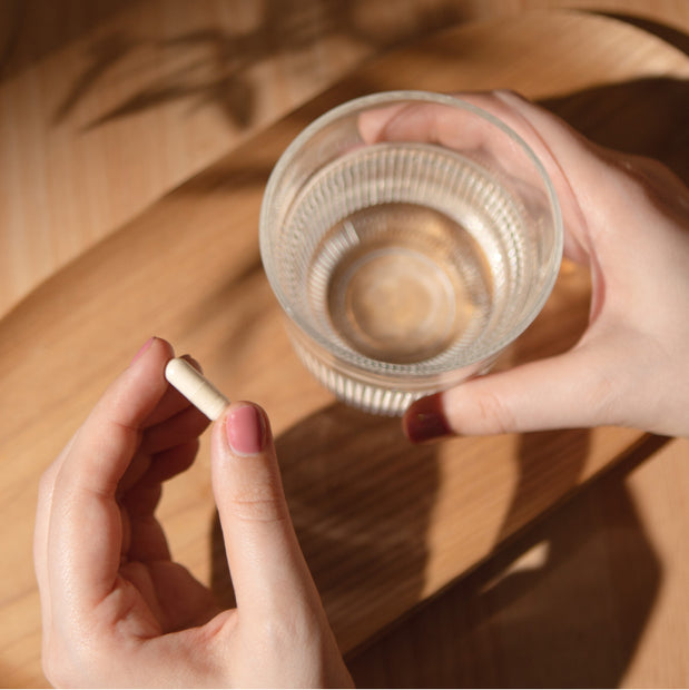 nu3 Capsula di vitamina C biologica e un bicchiere d'acqua