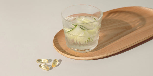 Omega-3 vegan con un bicchiere d'acqua