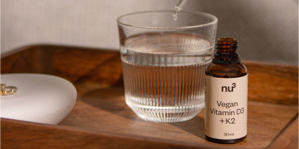 Vitamina D vegan nu3 e bicchiere d'acqua
